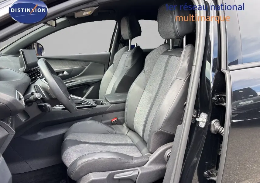 Vue intérieure côté conducteur du Peugeot 3008 Hybrid 180ch Allure 2024 noir métal, sièges tissu et cuir bicolore.