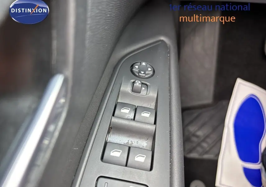 Gros plan sur les commandes des vitres et rétroviseurs côté conducteur d’un Peugeot 3008 noir métal 2024.