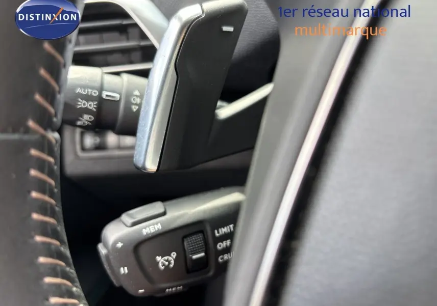 Gros plan sur la commande de régulateur de vitesse au volant d’un Peugeot 3008 noir métal 2024 hybride rechargeable.