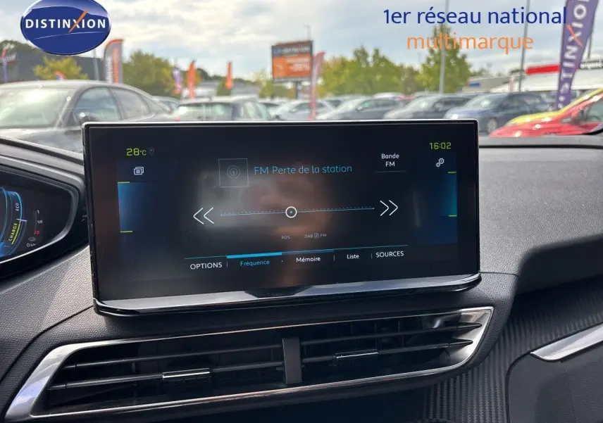 Écran tactile central du tableau de bord d’un Peugeot 3008 noir métal 2024, affichant la radio FM en extérieur.