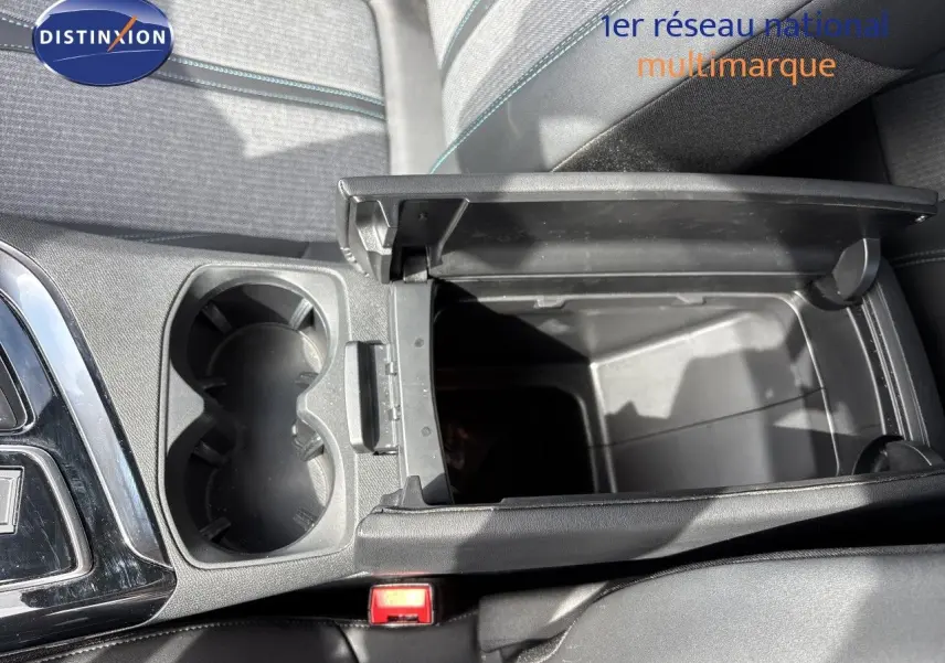 Vue intérieure en plongée du rangement central ouvert et porte-gobelets du Peugeot 3008 Hybrid noir métal, finition Allure 2024.