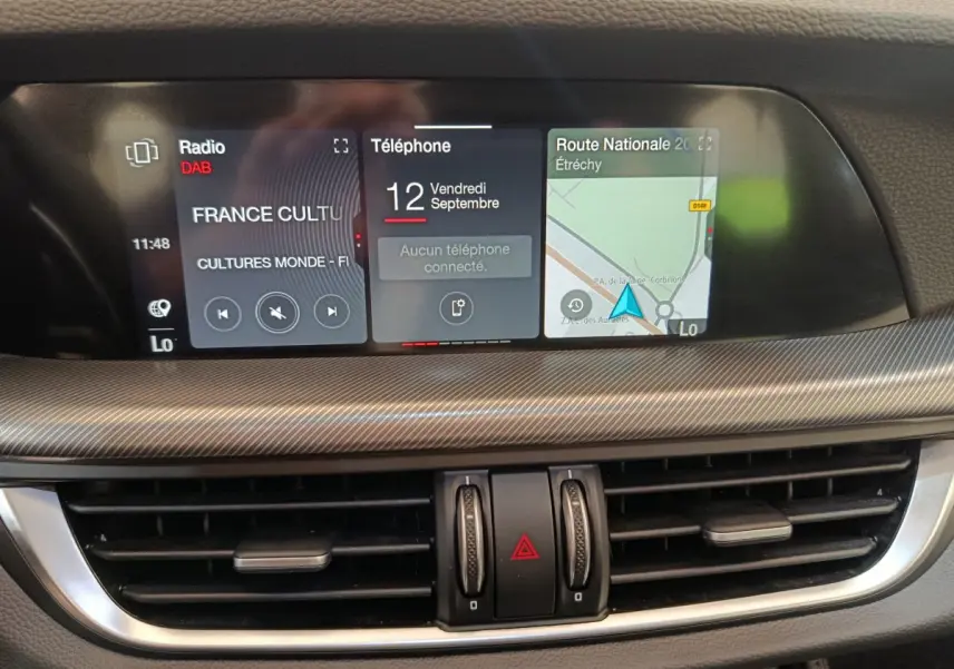 Détail du tableau de bord de l'Alfa Romeo Stelvio 2024 avec écran tactile multifonctions et aérateurs centraux.