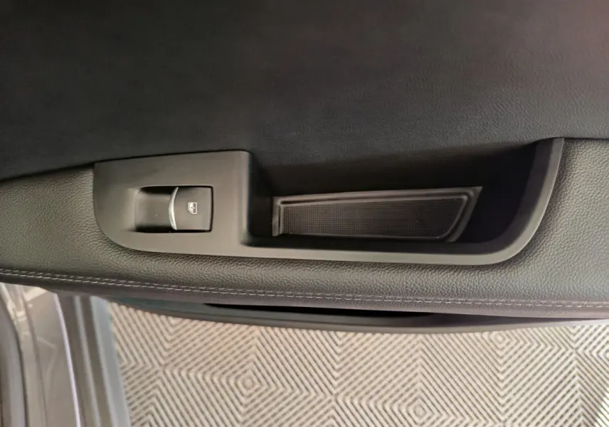 Détail de la commande de lève-vitre côté gauche sur la porte intérieure grise de l'Alfa Romeo Stelvio 2024.
