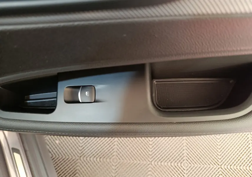 Gros plan sur la commande de lève-vitre côté gauche de l'Alfa Romeo Stelvio gris foncé 2024, intérieur noir.