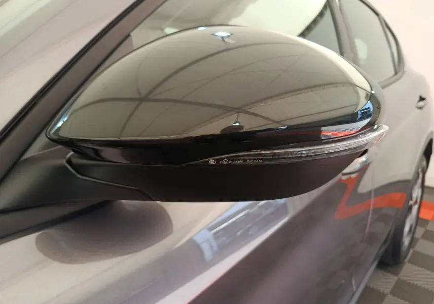 Gros plan sur le rétroviseur côté droit gris foncé de l'Alfa Romeo Stelvio 2024 avec clignotant intégré.