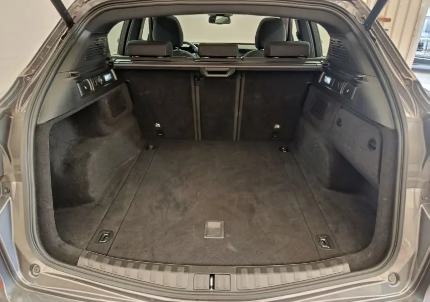 Coffre ouvert vu de l'arrière d'un Alfa Romeo Stelvio gris foncé, montrant un espace de chargement propre et spacieux.