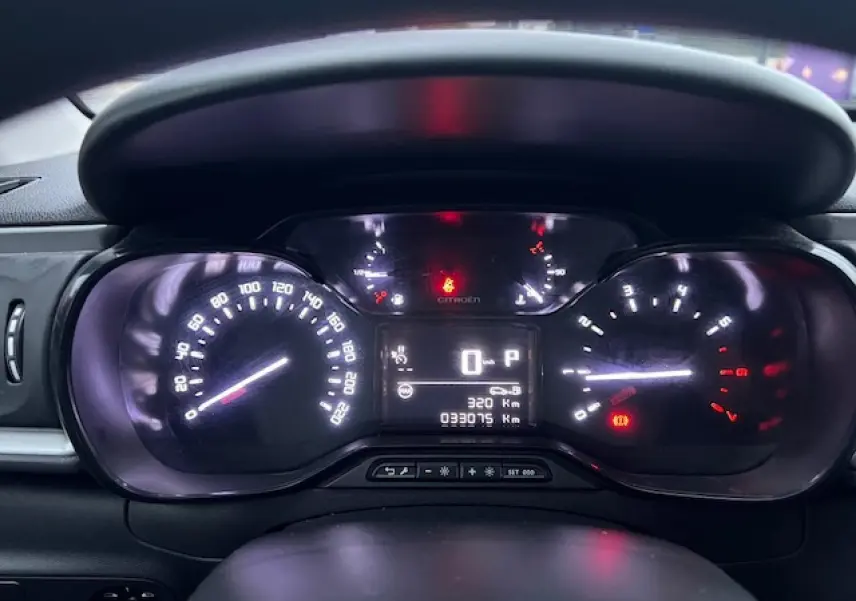 Vue rapprochée du tableau de bord numérique de la Citroën C3 Shine 2023, affichant le compteur et les voyants allumés.