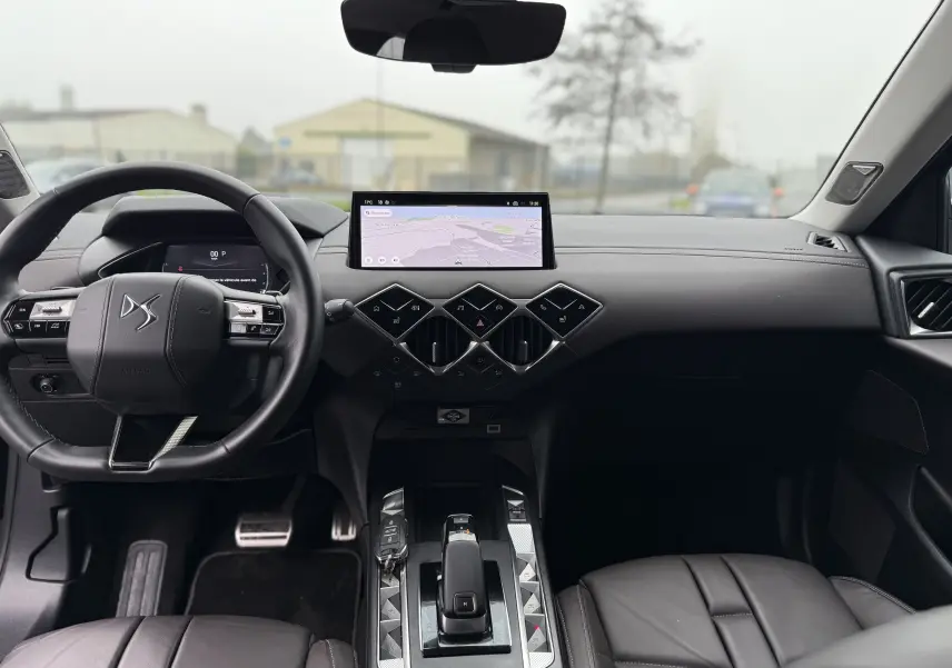 Intérieur du DS3 BlueHDi 130 2024 en cuir noir, vue frontale du tableau de bord avec écran tactile et volant multifonction.