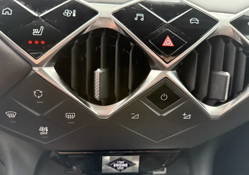 Gros plan sur la console centrale du DS3 2024 noir Perla Nera, montrant les aérateurs et commandes tactiles en losange.