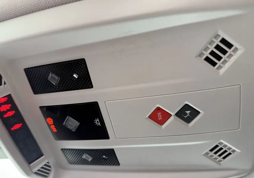 Panneau de commandes au plafond intérieur de la DS3 2024 noir Perla Nera, avec boutons SOS et éclairage, vue en gros plan.