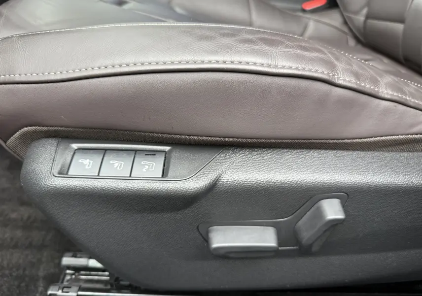 Gros plan sur les commandes électriques du siège avant en cuir marron du DS3 Noir Perla Nera 2024.