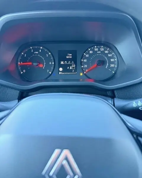 Vue rapprochée du tableau de bord du Renault Trafic Fourgon gris clair, avec compte-tours, compteur de vitesse et écran multifonctions.