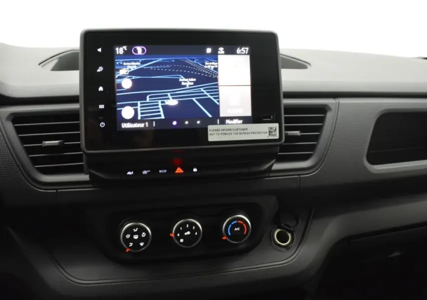 Tableau de bord central du Renault Trafic Fourgon gris clair 2025 avec écran tactile 8 pouces et commandes climatisation visibles.