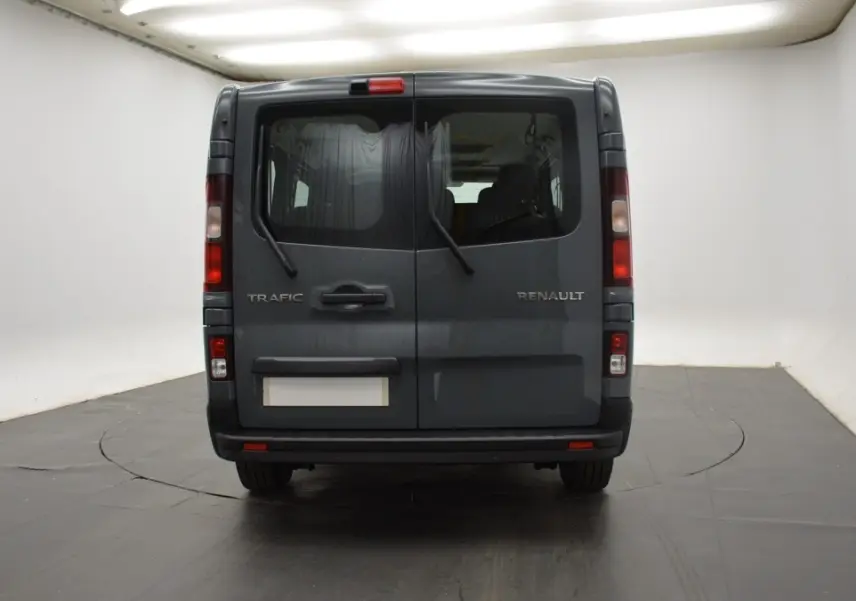 Vue arrière du Renault Trafic Fourgon gris clair 2025 avec portes battantes et essuie-glaces arrière visibles.