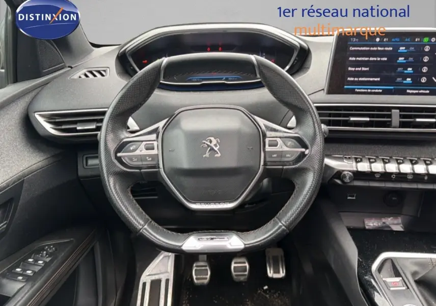 Vue intérieure centrée sur le volant cuir noir et le tableau de bord numérique du Peugeot 5008 GT Line 2018.
