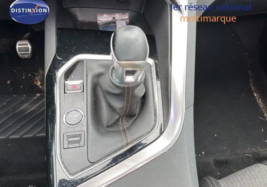 Vue rapprochée de la console centrale du Peugeot 5008 2018, levier de vitesse manuel avec surpiqûres marron.