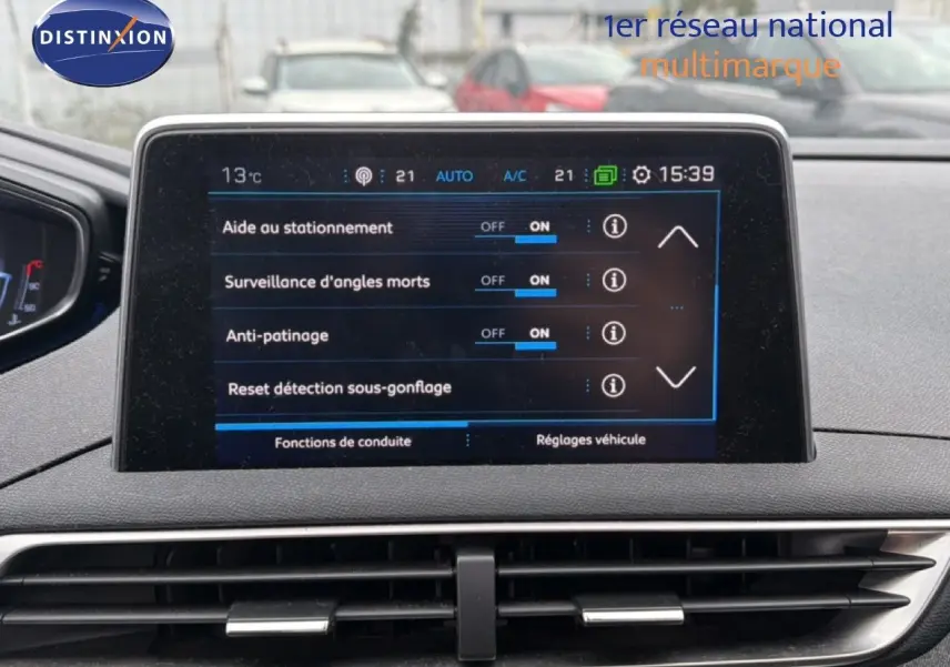 Vue intérieure centrée sur l’écran tactile du tableau de bord du Peugeot 5008 gris Artense, affichant les aides à la conduite.