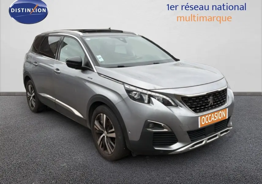 Peugeot 5008 gris Artense en 3/4 avant droit, SUV 5 portes avec jantes alliage et calandre noire distinctive.