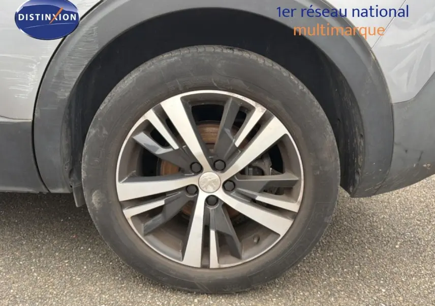 Gros plan sur la roue avant droite avec jante alliage bicolore du Peugeot 5008 gris Artense.