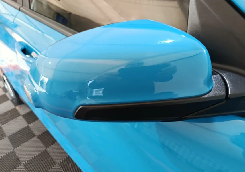 Rétroviseur côté conducteur bleu vif du Hyundai Kona électrique 2022, avec clignotant intégré noir.