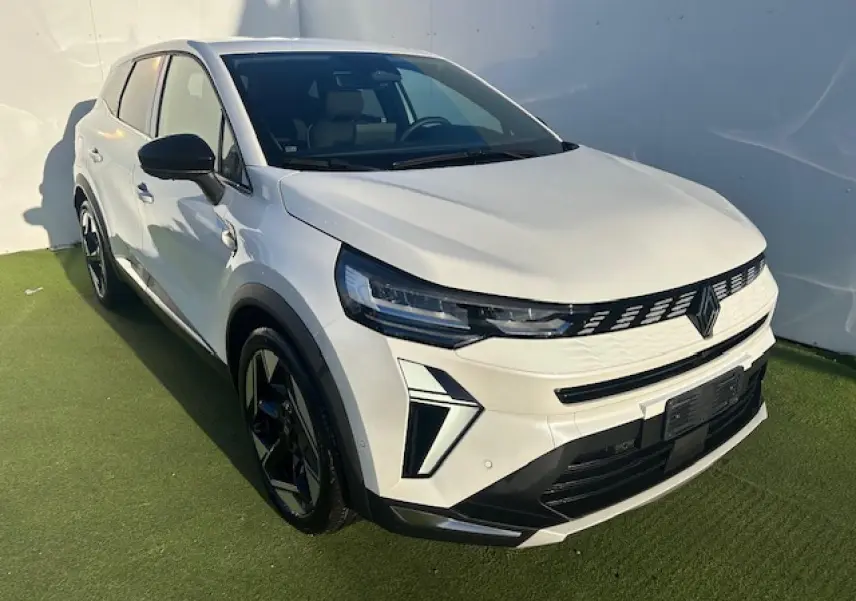 Renault Symbioz blanc nacré en 3/4 avant droit, avec calandre noire et jantes alliage noires distinctives.