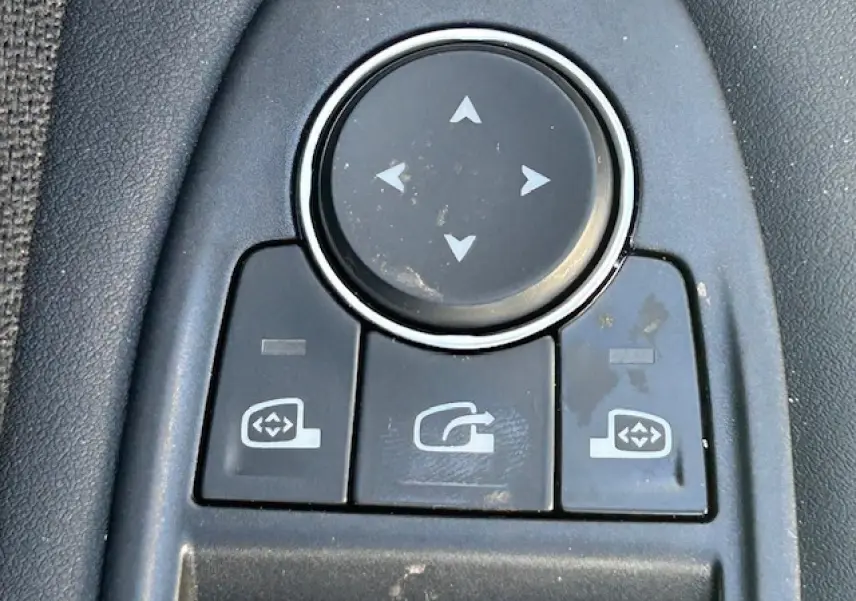 Gros plan sur les commandes de réglage des rétroviseurs intérieurs d’une Renault Symbioz blanc nacré.