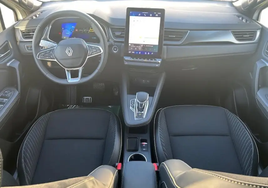 Vue intérieure avant du Renault Symbioz 2025, tableau de bord noir avec écran tactile vertical et volant multifonction.