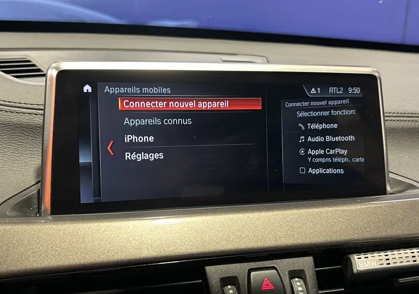 Écran central du tableau de bord d'une BMW X1 gris 2021 affichant le menu de connexion Bluetooth et Apple CarPlay.