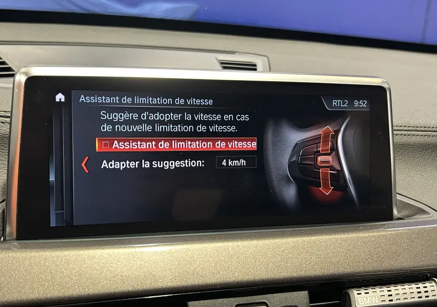 Écran central du tableau de bord BMW X1 2021 affichant l'assistant de limitation de vitesse en mode réglage.