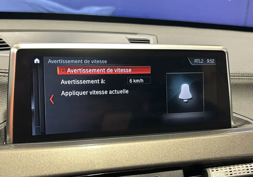 Écran central du tableau de bord d'une BMW X1 gris 2021 affichant le menu d'avertissement de vitesse à 6 km/h.