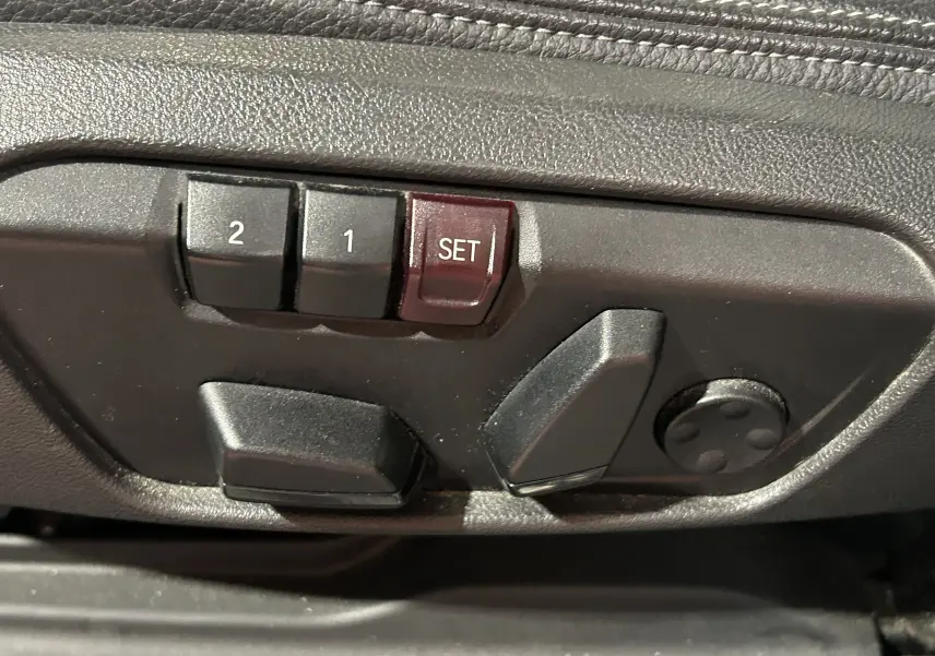 Boutons de réglage électrique des sièges avec mémorisation sur le côté gauche d'un BMW X1 gris 2021.