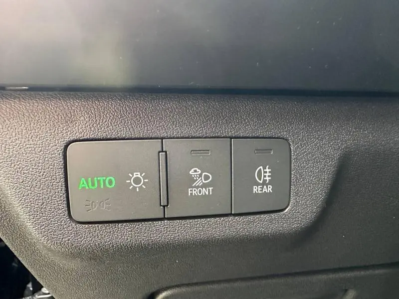 Gros plan sur les commandes d’éclairage automatiques et antibrouillard avant et arrière de l’Audi Q3 noir Mythique.