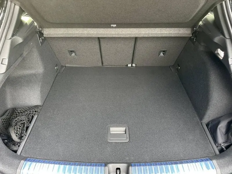 Coffre spacieux ouvert d’un Audi Q3 noir Mythique métallisé, montrant le plancher plat et les dossiers arrière rabattables.