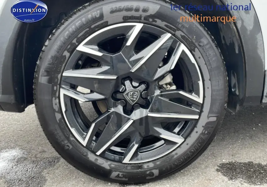 Gros plan sur la jante alu noire et argentée du côté gauche d’un Peugeot 3008 blanc hybride 2025.