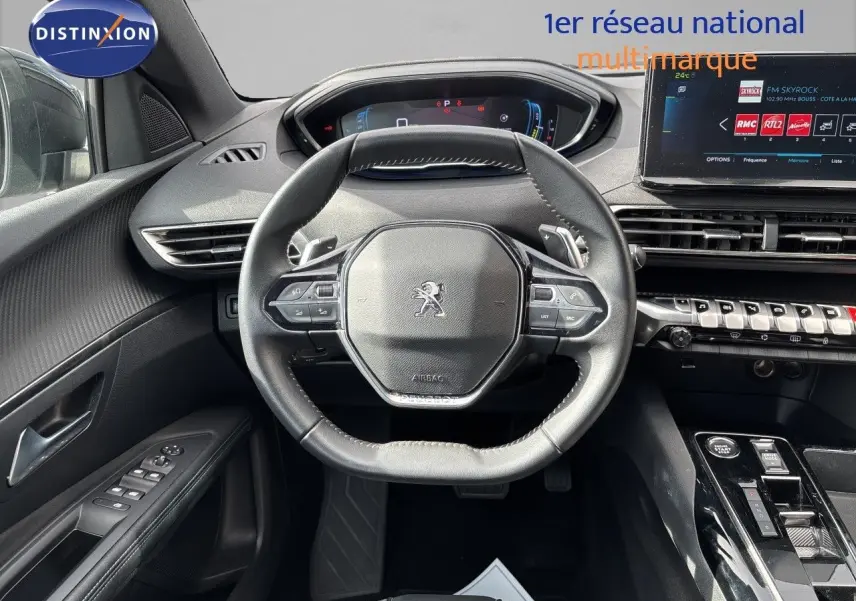 Vue intérieure centrée sur le volant cuir et le tableau de bord numérique du Peugeot 3008 gris platinium 2024.