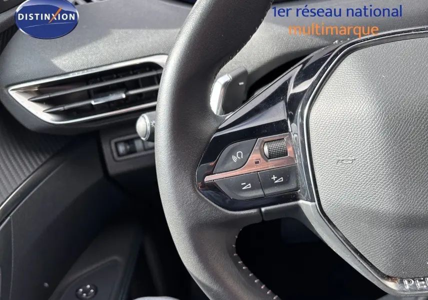 Gros plan sur le volant cuir noir de la Peugeot 3008 2024, montrant les commandes multifonctions côté gauche.