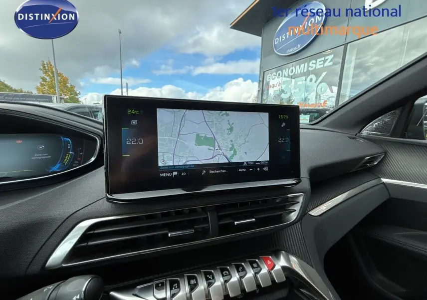 Vue intérieure du tableau de bord du Peugeot 3008 Hybrid 2024 avec écran tactile central et finitions noires modernes.