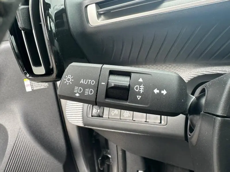 Gros plan sur la commande des feux à gauche du volant dans l’habitacle gris et noir du Citroën C3 Aircross 2026.