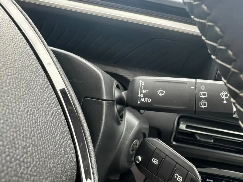 Gros plan sur la commande d’essuie-glace côté droit du volant d’une Citroën C3 Aircross gris Mercury, intérieur noir.