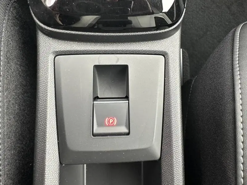 Vue rapprochée du frein à main électronique avec témoin rouge sur la console centrale noire du Citroën C3 Aircross 2026.