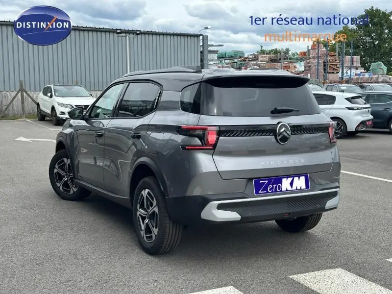 Vue 3/4 arrière droite d'un Citroën C3 Aircross gris Mercury avec toit noir et jantes alu distinctives.