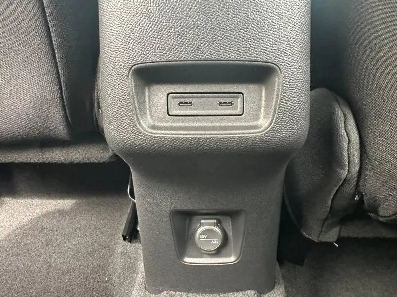 Vue rapprochée de la console arrière noire avec prises USB et prise 12V dans une Citroën C3 Aircross gris Mercury.