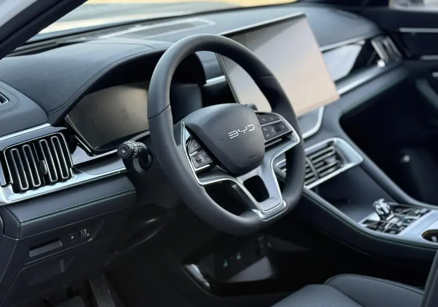 Vue intérieure centrée sur le volant noir multifonction du BYD SEAL U avec tableau de bord et console moderne.