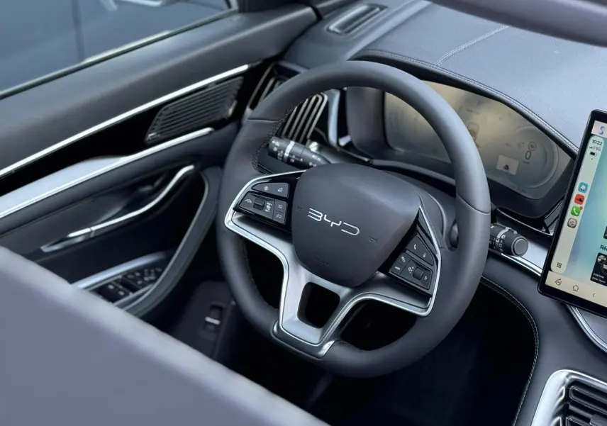 Vue intérieure côté conducteur du volant noir multifonction BYD SEAL U avec tableau de bord digital et écran tactile.