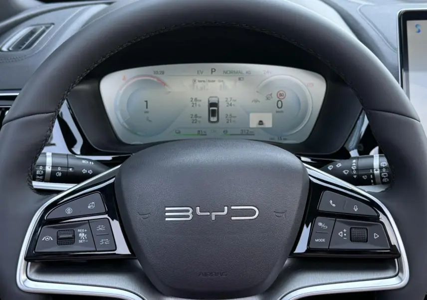 Vue rapprochée du volant noir de la BYD SEAL U 1.5 DM-i 218 Boost avec commandes multifonctions et tableau de bord digital.