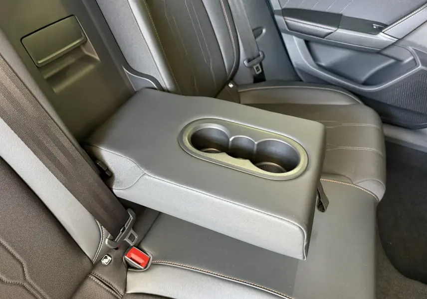 Détail de l'accoudoir central arrière avec porte-gobelets dans l'habitacle gris foncé du CUPRA Formentor 2026.