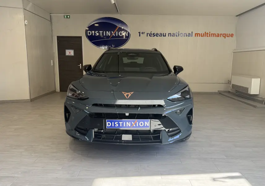 Vue frontale d'un CUPRA Formentor gris 2026 avec logo cuivré et calandre large dans un showroom.