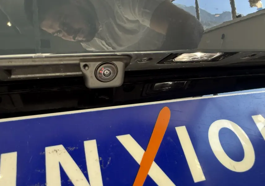 Gros plan sur la caméra de recul intégrée au hayon arrière du CUPRA Formentor gris, avec plaque d'immatriculation partiellement visible.