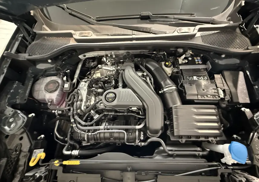 Vue plongeante sur le moteur essence gris du CUPRA Formentor 1.5 eTSI 150CH DSG7 avec batterie et réservoir de liquide visible.