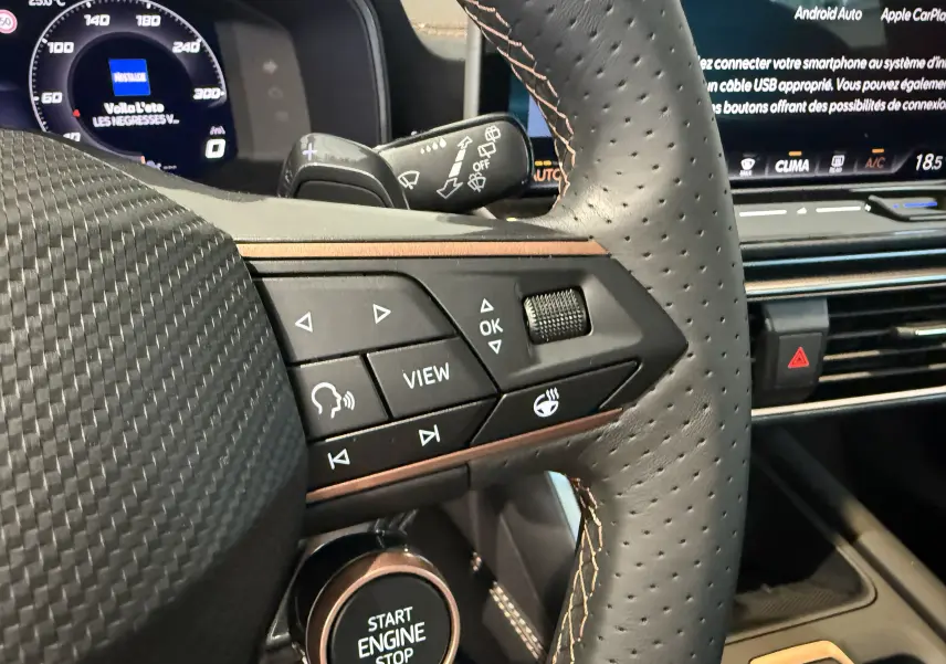 Gros plan sur le volant perforé gris du CUPRA Formentor 2026, avec commandes multifonctions et bouton Start Engine Stop visible.